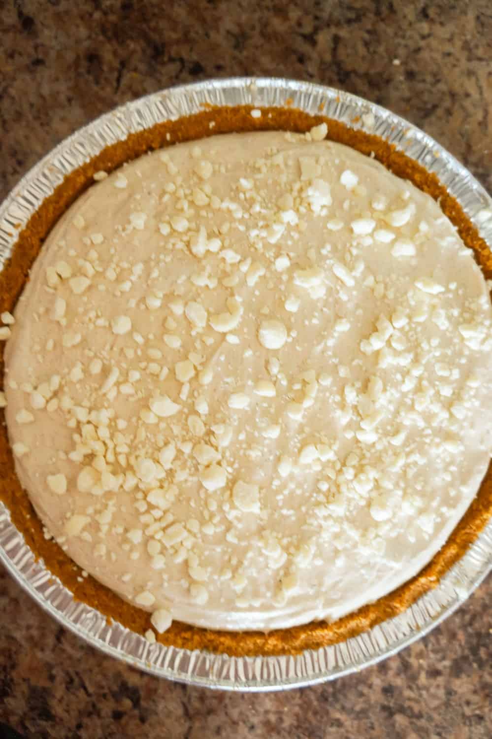 crumbled white chocolate on top of pumpkin spice cheesecake