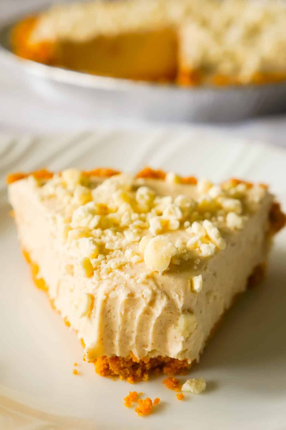 No Bake Pumpkin Spice White Chocolate Cheesecake is an easy fall dessert recipe made with pumpkin pie spice, white chocolate, Cool Whip and a graham cookie pie crust.