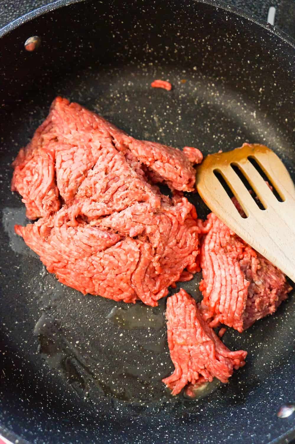 raw ground beef in a saute pan