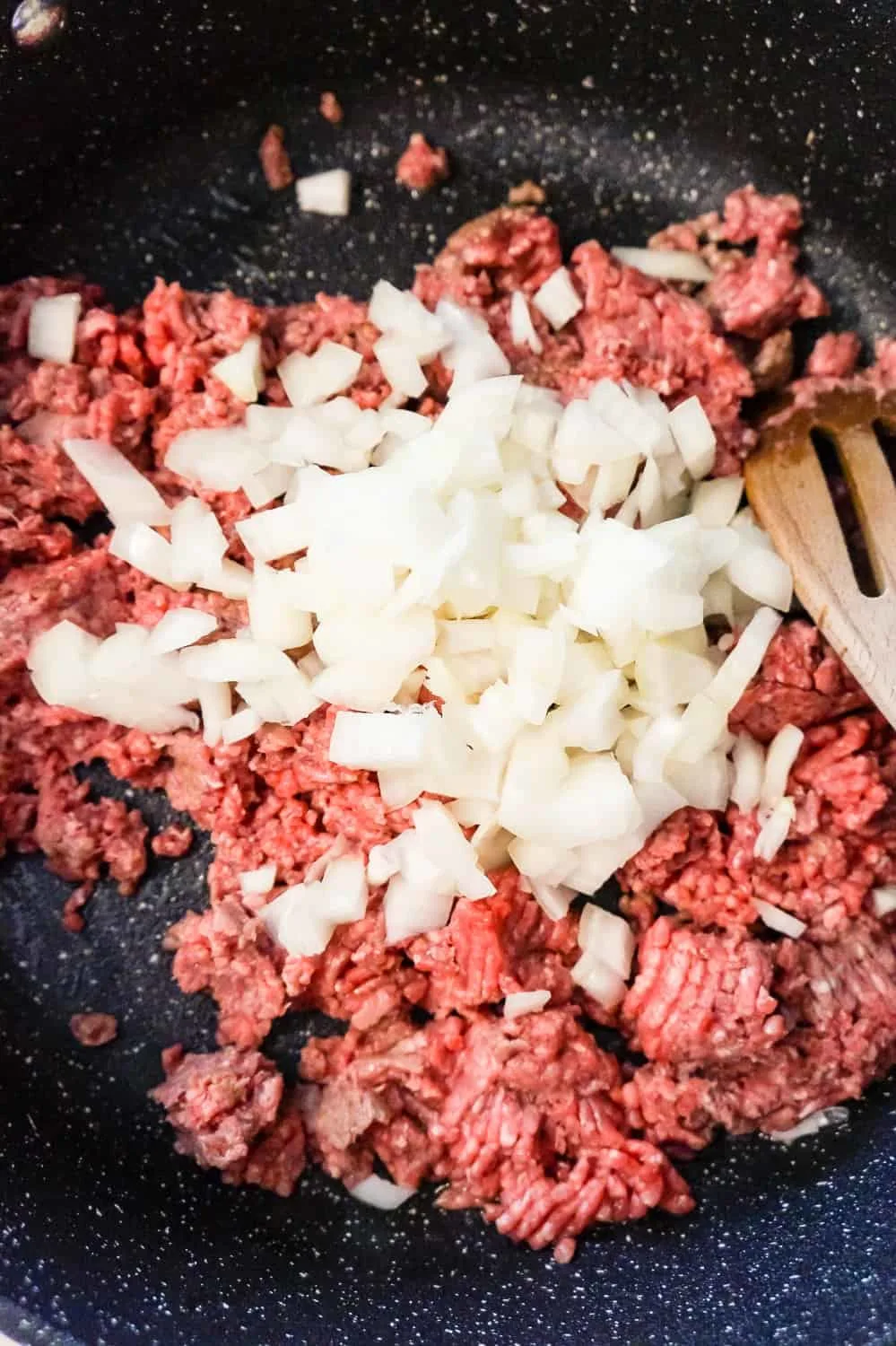 diced onions and raw ground beef in a saute pan