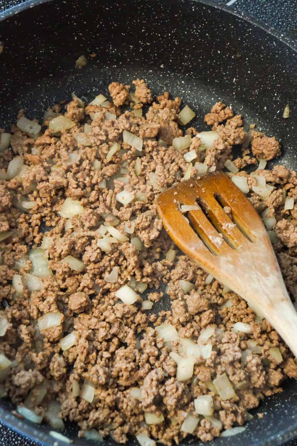 cooked ground beef and diced onions in a saute pan