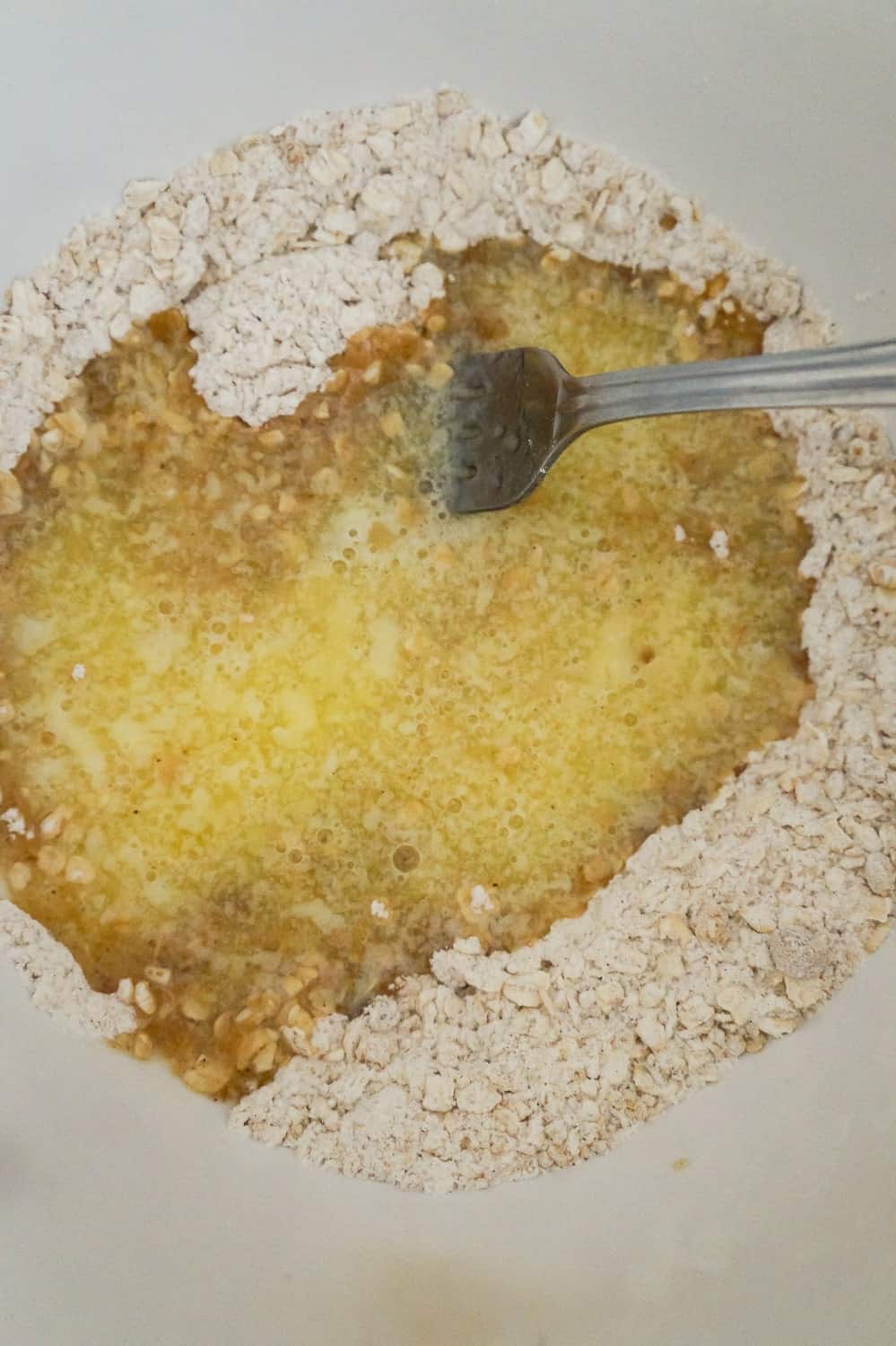 melted butter with flour and oats in a mixing bowl