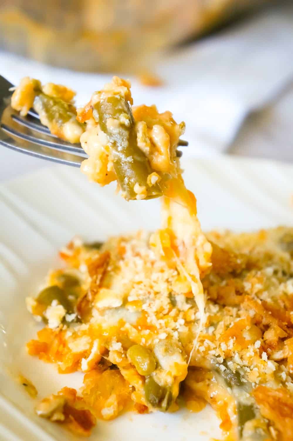Cheesy Green Bean Casserole is an easy side dish recipe made with Campbell's cheddar cheese soup, shredded Parmesan, mozzarella, cheddar and topped with Townhouse Light and Buttery Original Crackers and French's Fried Onions.