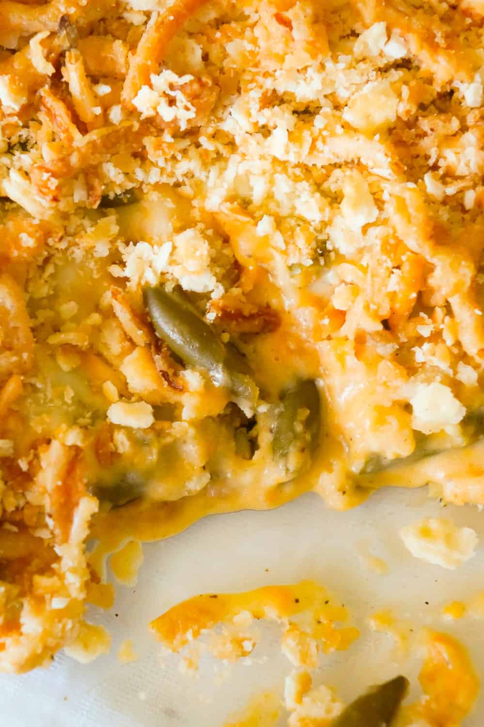 Cheesy Green Bean Casserole is an easy side dish recipe made with Campbell's cheddar cheese soup, shredded Parmesan, mozzarella, cheddar and topped with Townhouse Light and Buttery Original Crackers and French's Fried Onions.