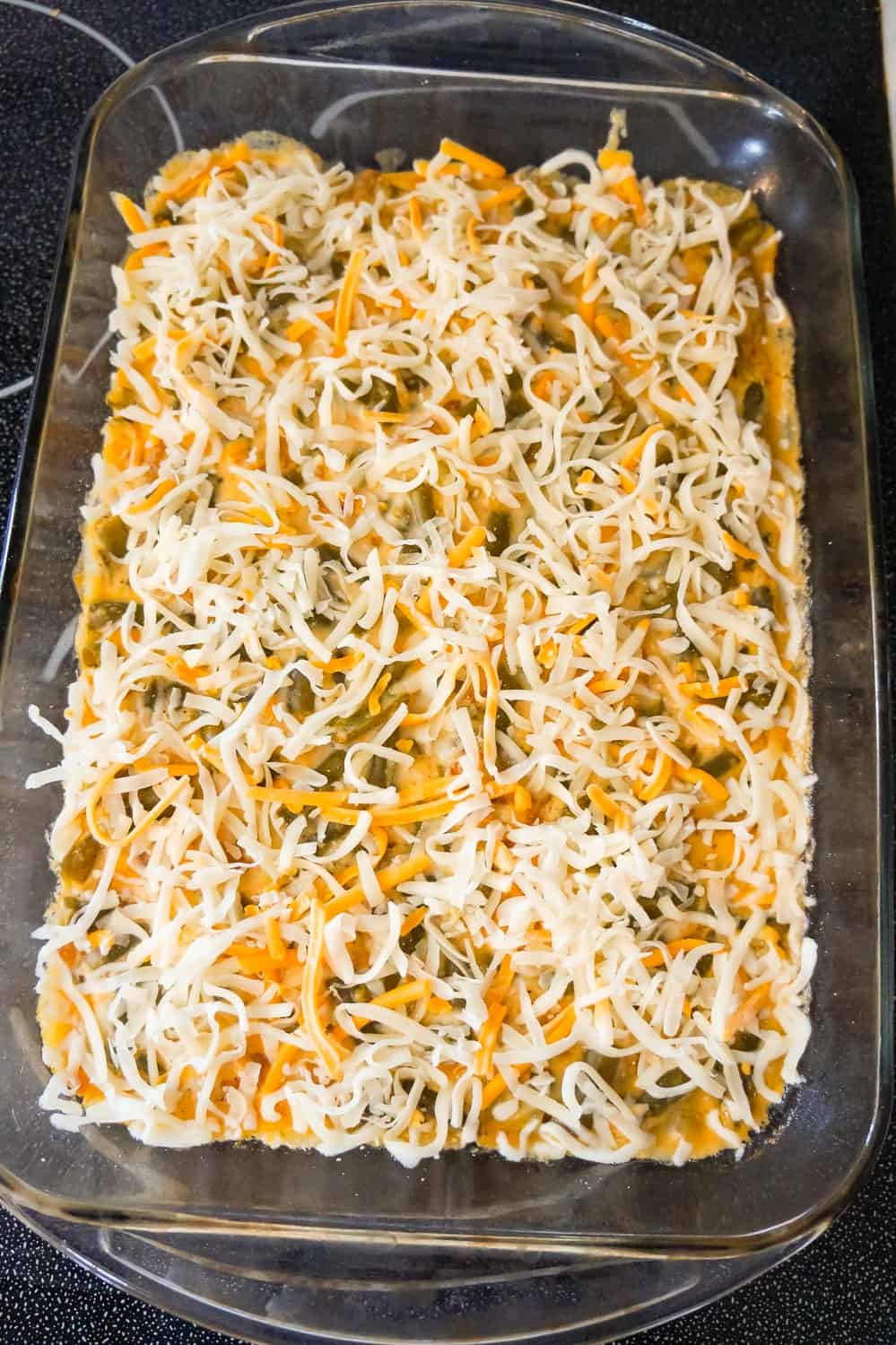 shredded mozzarella and cheddar cheese on top of green bean casserole