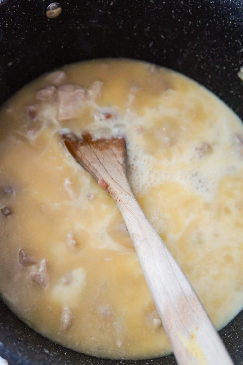 milk and chicken broth added to chicken and onion mixture in a pot
