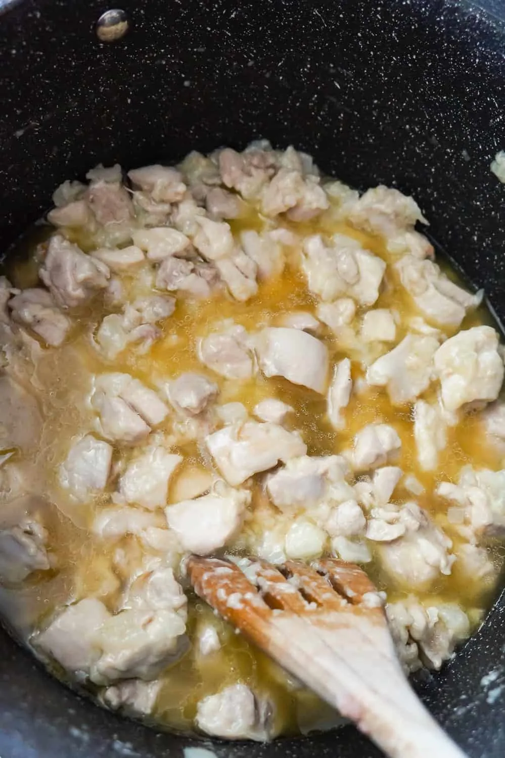 chicken broth added to chicken and onion mixture in a mixing bowl