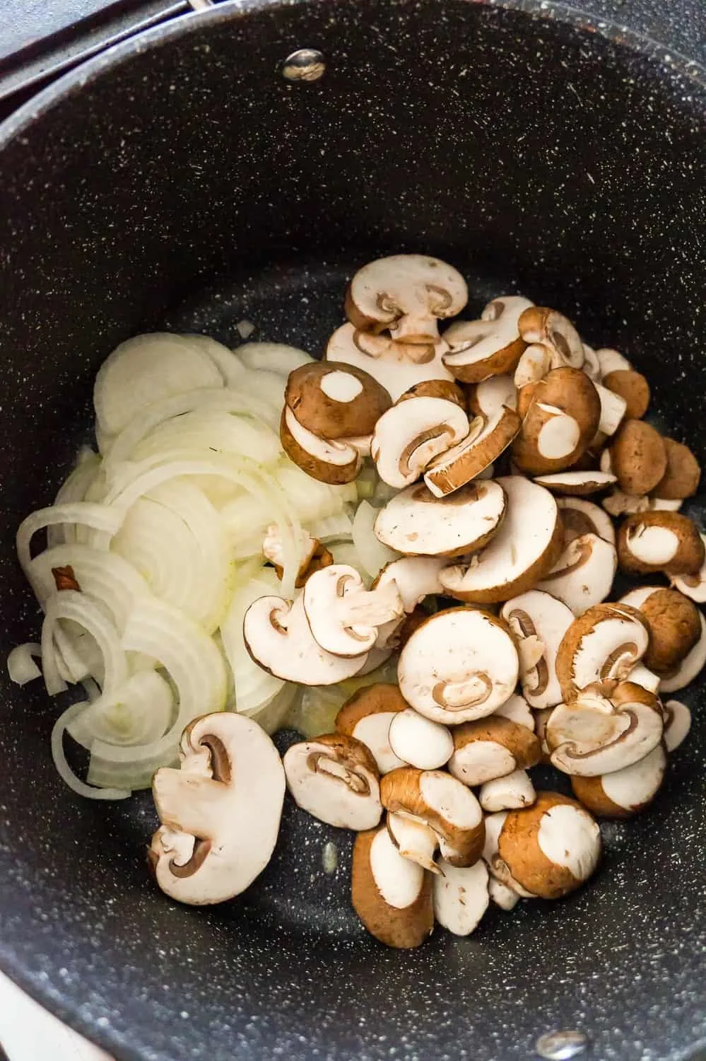sliced onions and sliced mushrooms in a large pan
