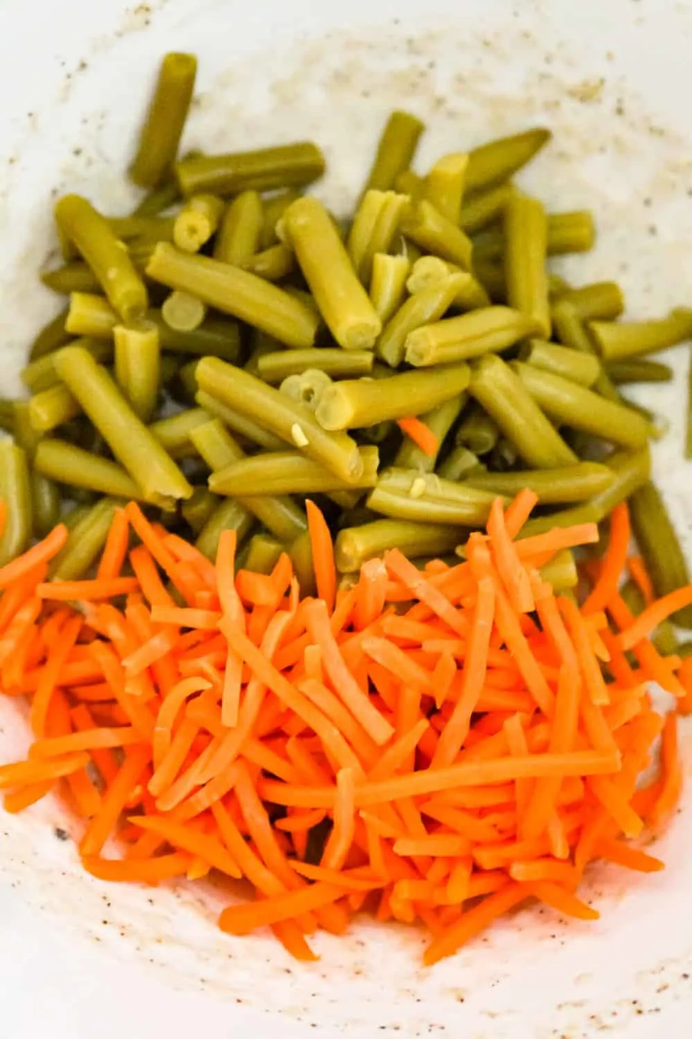 cut green beans and matchstick carrots in a mixing bowl