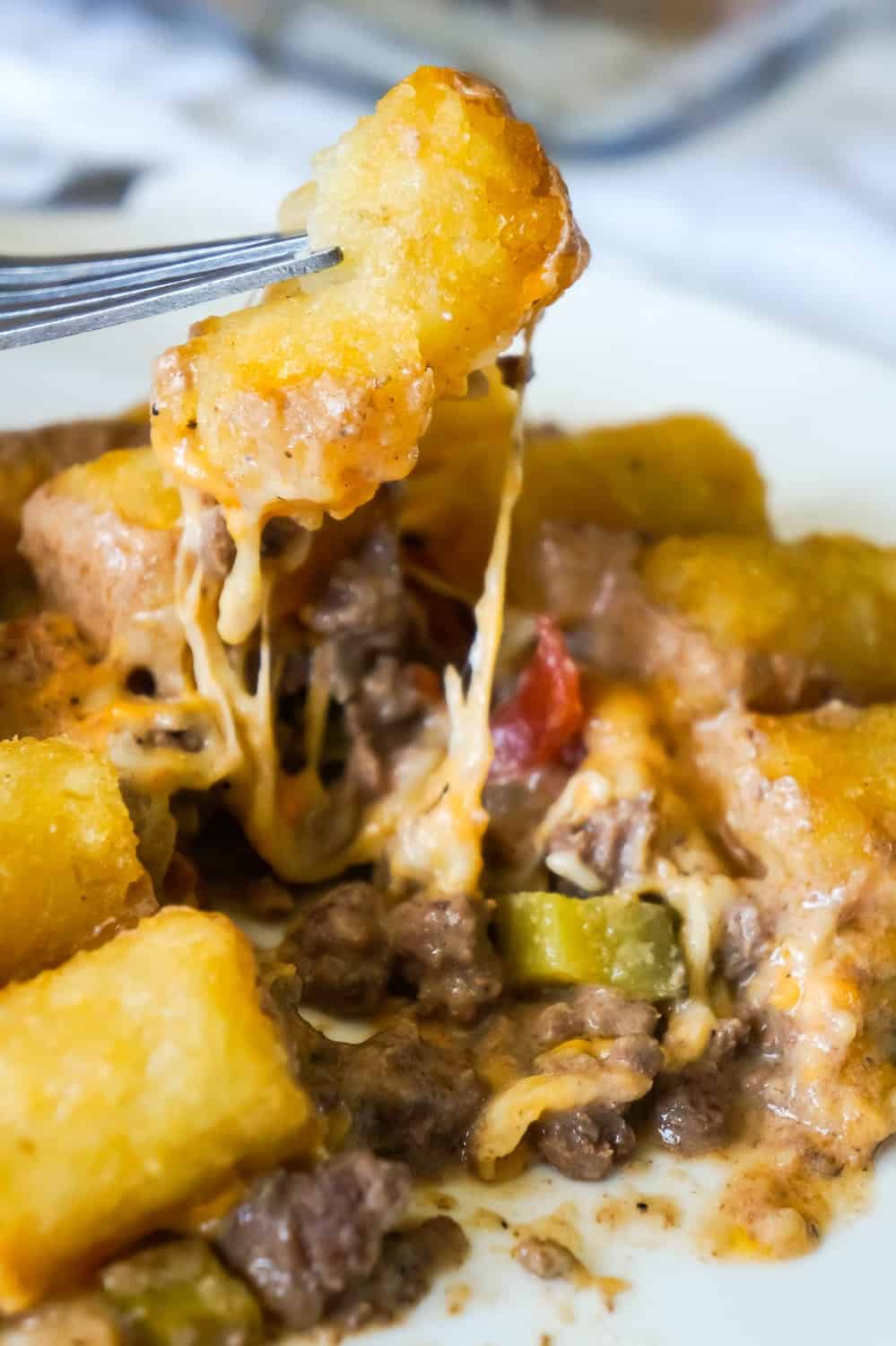 Hamburger Casserole with Tater Tots is an easy ground beef casserole recipe made with cream of mushroom soup, diced dill pickles and diced tomatoes, all topped with cheese and potatoes.