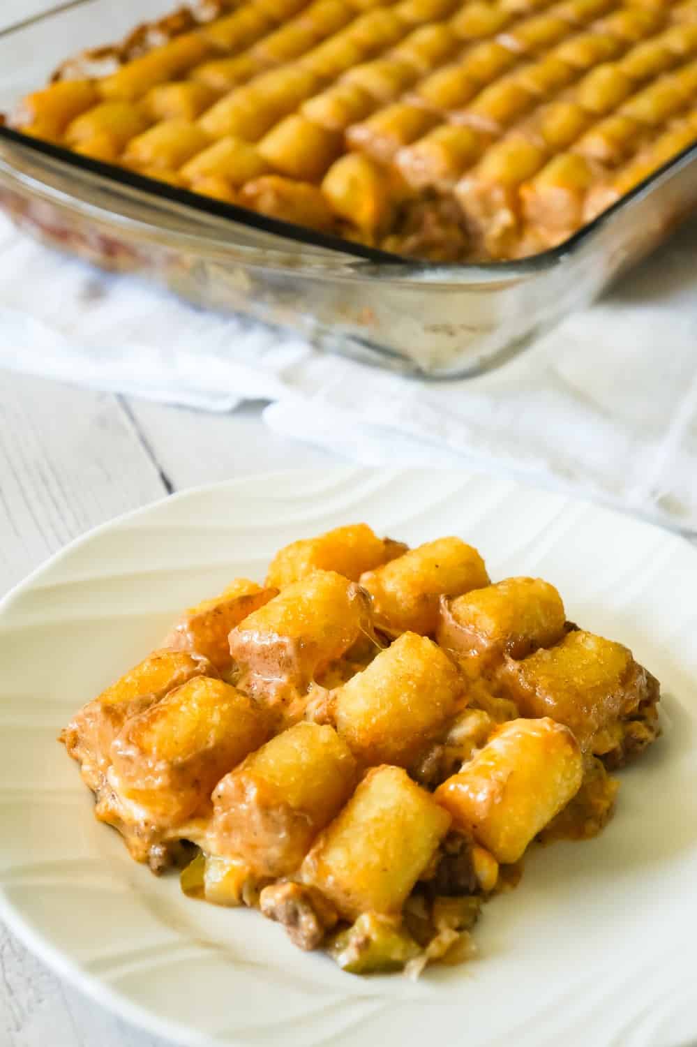 Hamburger Casserole with Tater Tots is an easy ground beef casserole recipe made with cream of mushroom soup, diced dill pickles and diced tomatoes, all topped with cheese and potatoes.