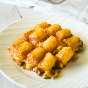 Hamburger Casserole with Tater Tots is an easy ground beef casserole recipe made with cream of mushroom soup, diced dill pickles and diced tomatoes, all topped with cheese and potatoes.