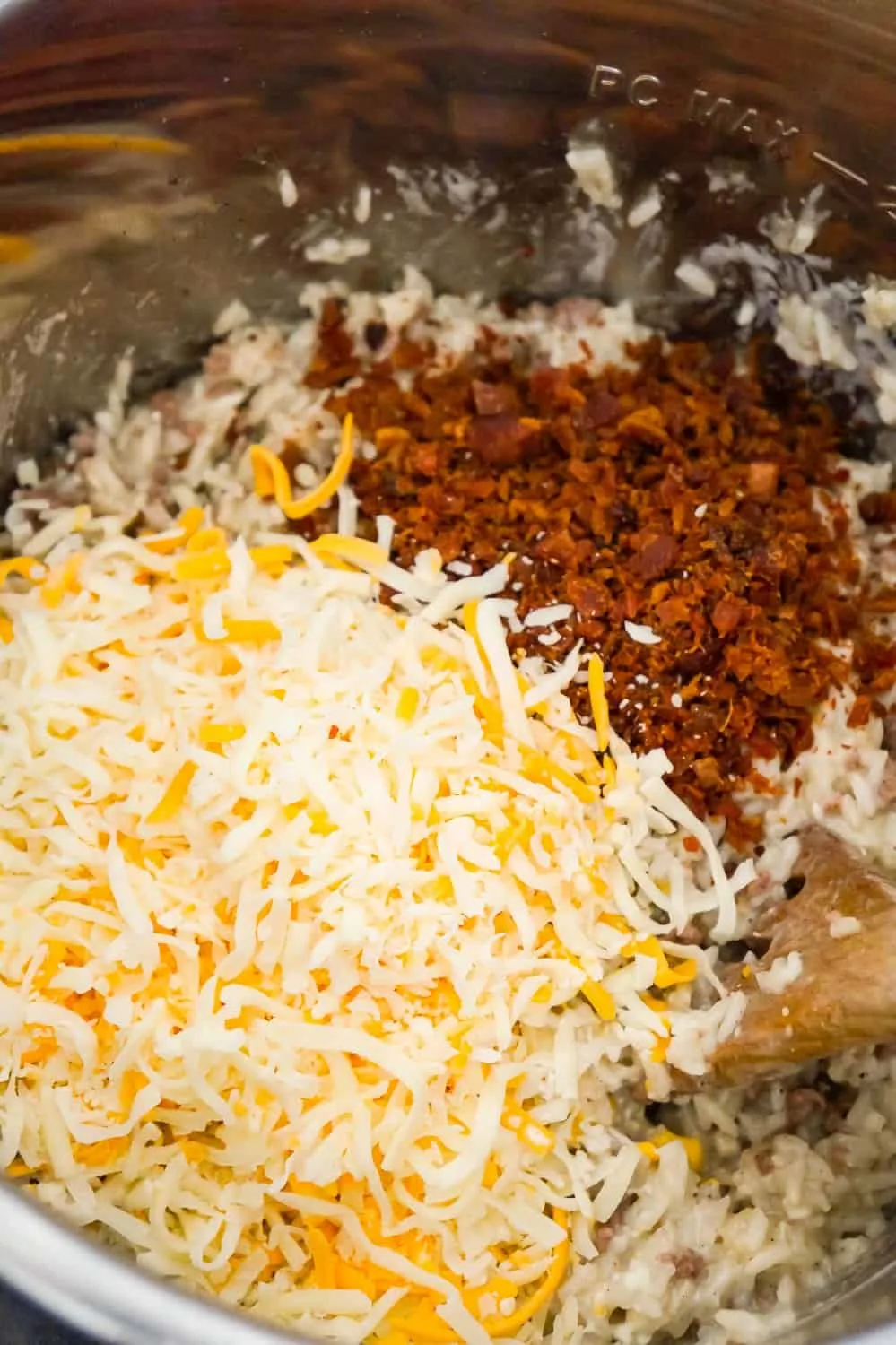 shredded mozzarella, cheddar and crumbled bacon on top of ground beef and rice in an Instant Pot
