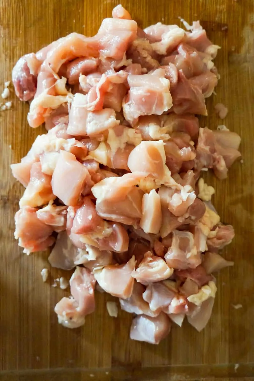 chunks of raw chicken on a cutting board