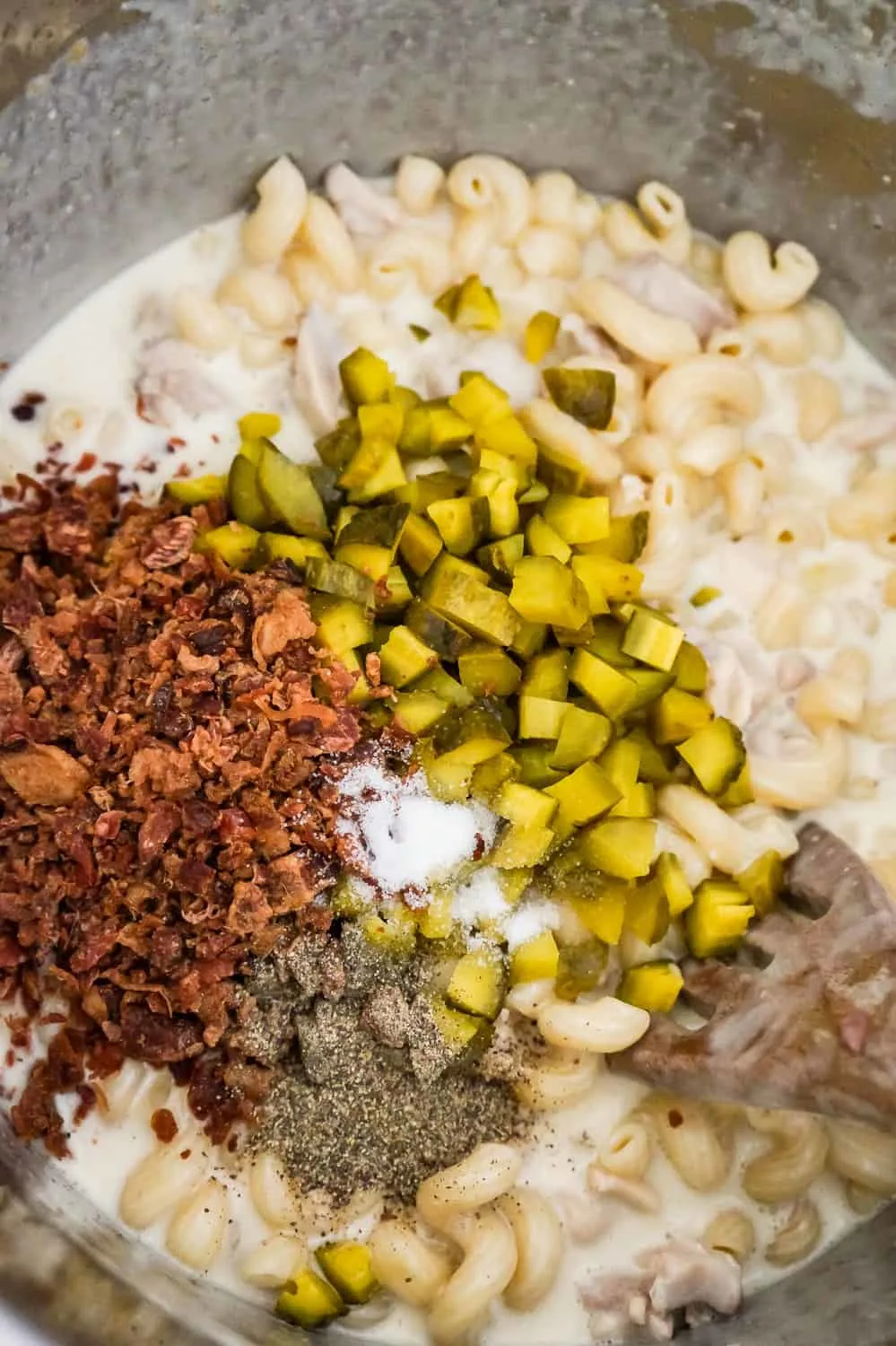 crumbled bacon, spices and diced dill pickles on top of creamy pasta in an Instant Pot