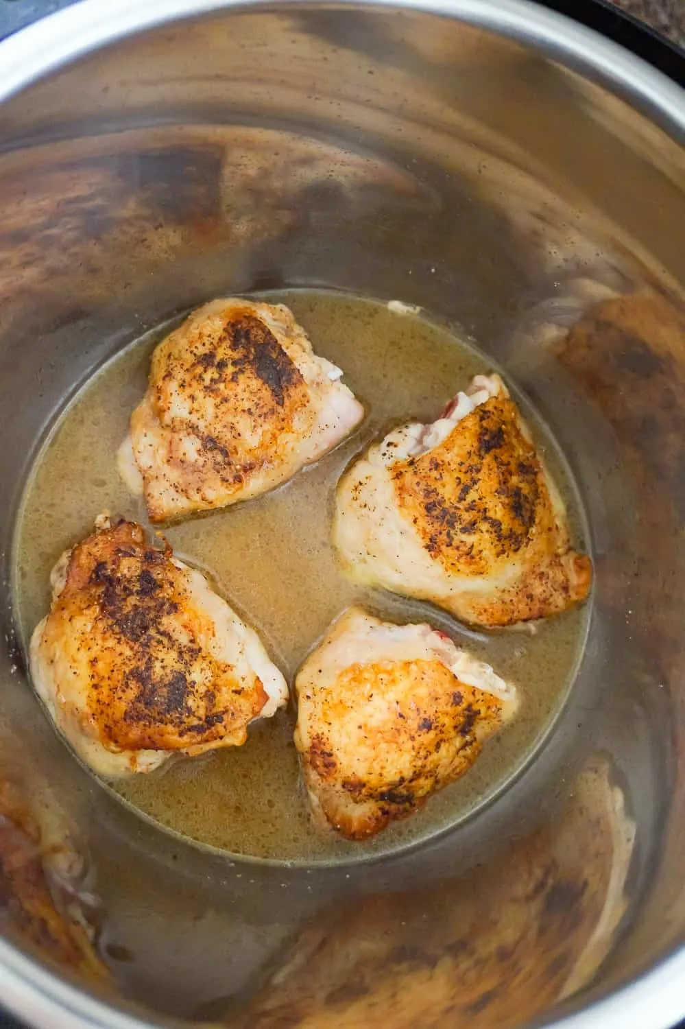 condensed chicken broth and seared chicken thighs in an Instant Pot