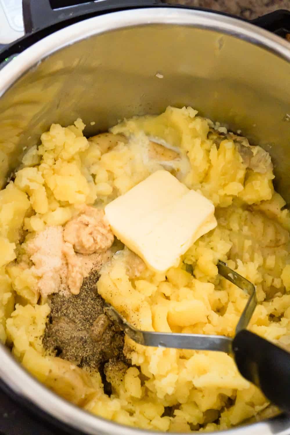 butter and spices on top of mashed potatoes in an Instant Pot