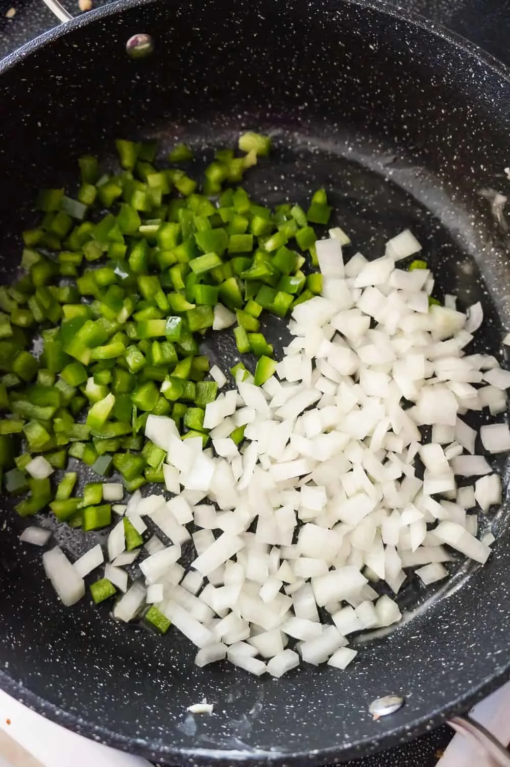 diced green peppers and diced onions in a saute pan