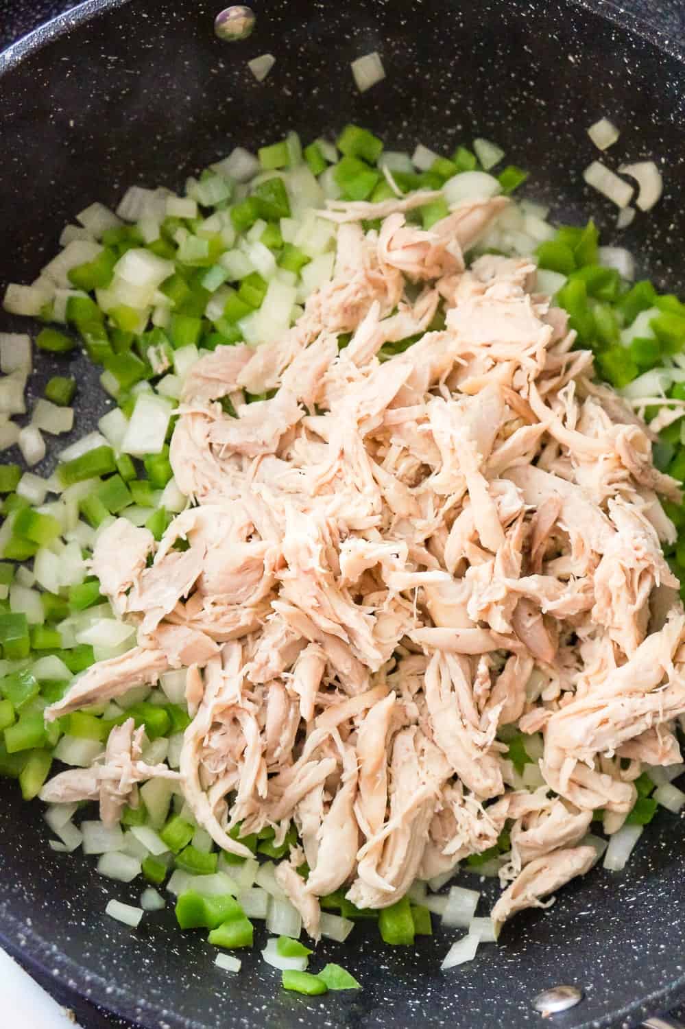 shredded chicken, diced green peppers and diced onions in a saute pan