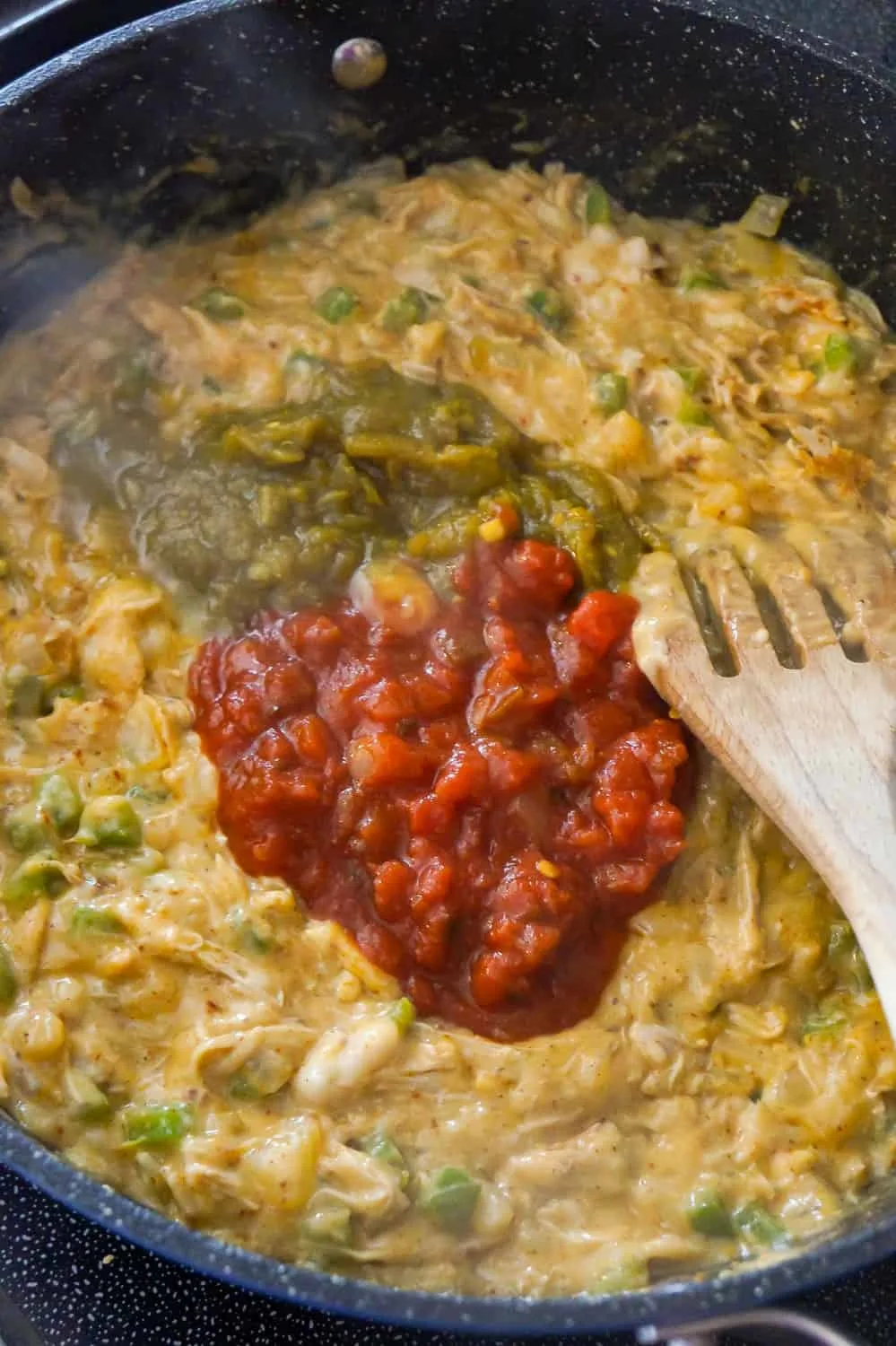 salsa and green chilies on top of creamy chicken mixture in a saute pan