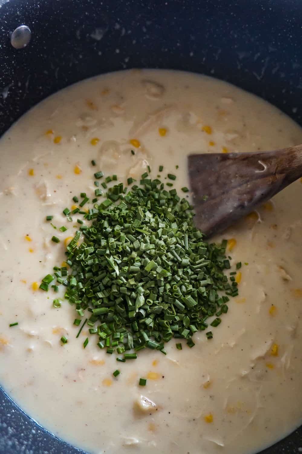 chopped chives on top of turkey soup in a large pot