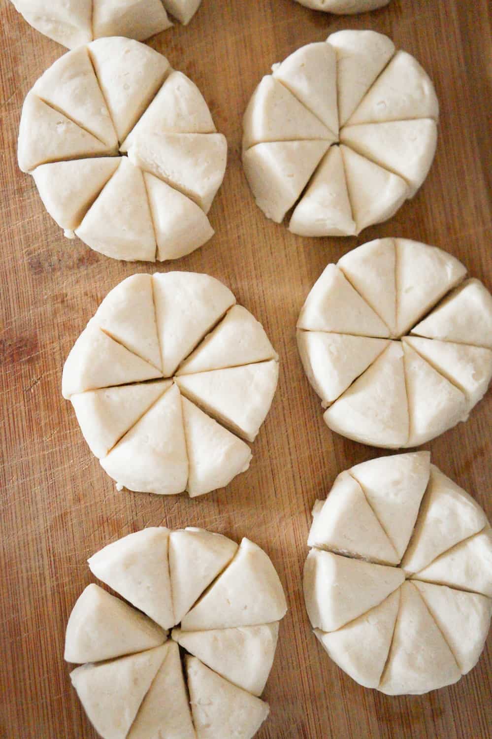 Pillsbury biscuits cut into pieces on a cutting board