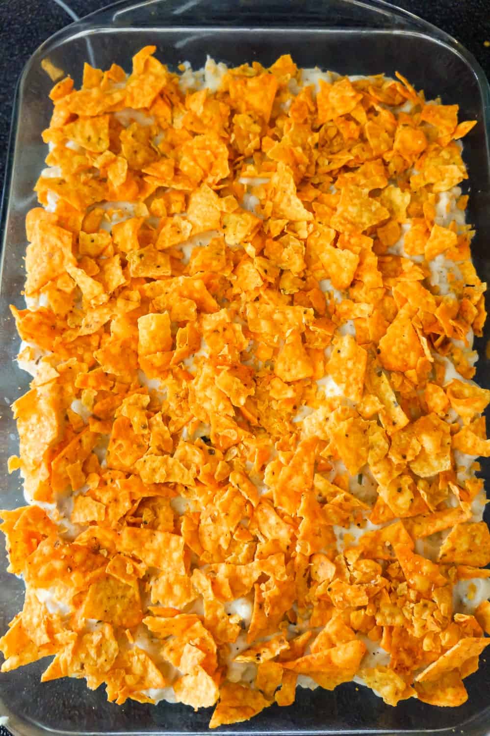 crumbled Doritos on top of mac and cheese in a baking dish
