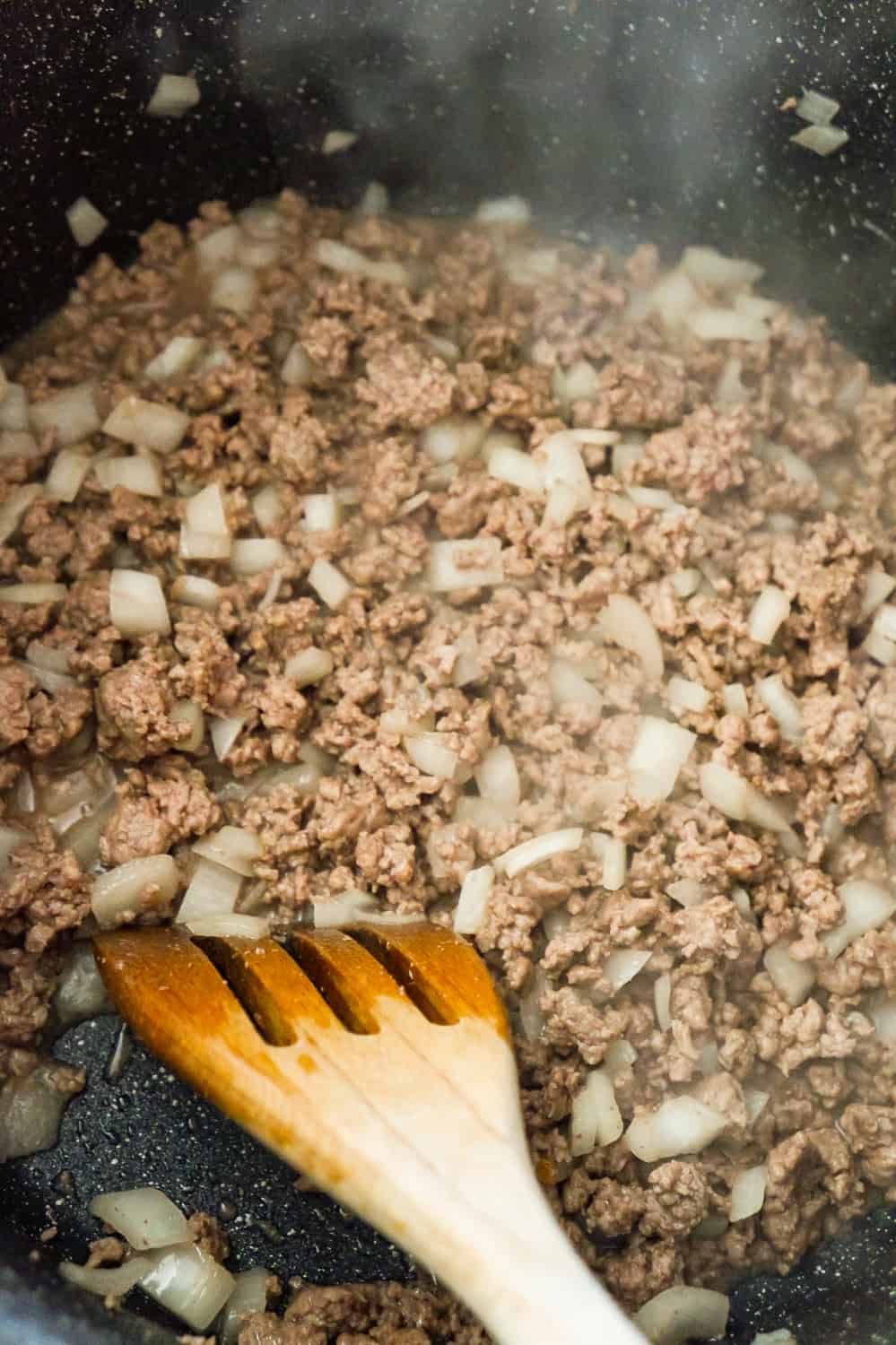 diced onions and ground beef cooking in a large pot