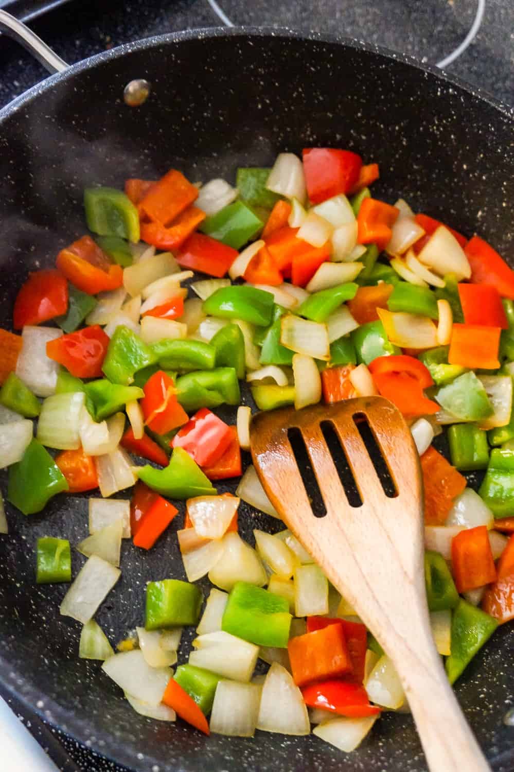 diced red peppers, green peppers and onions in a saute pan