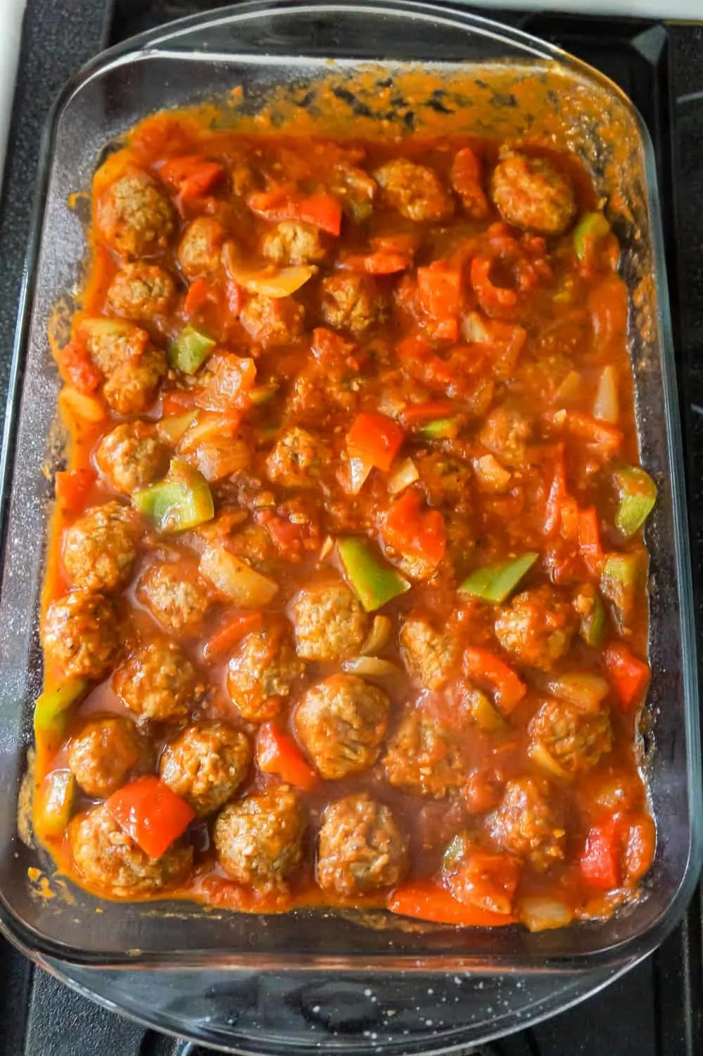meatballs. marinara and chopped peppers in a baking dish