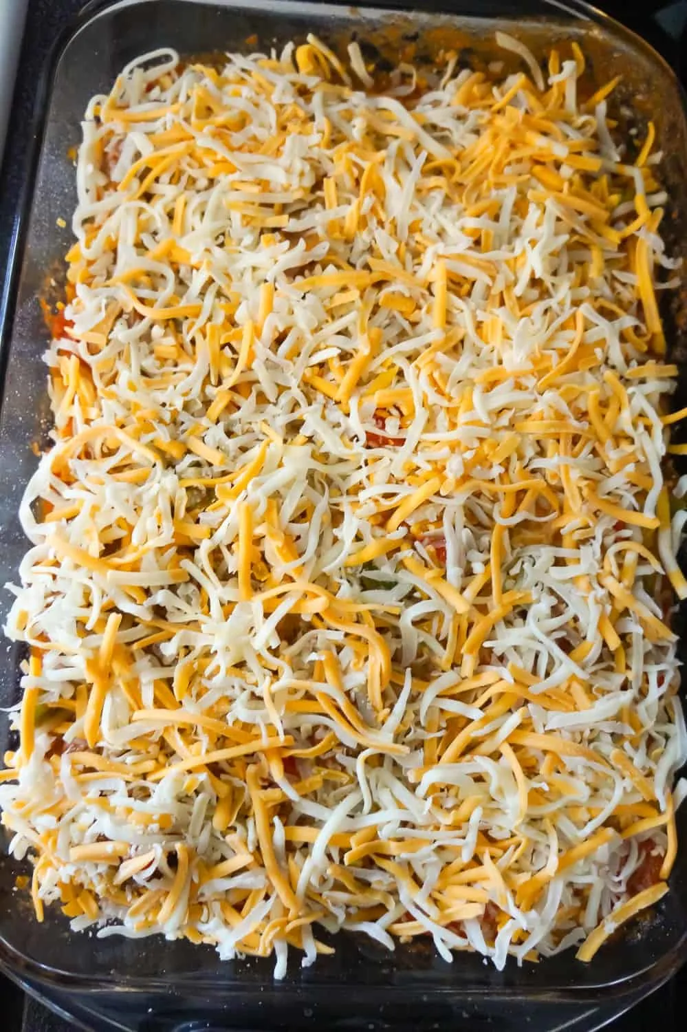 shredded mozzarella and cheddar cheese on top of meatball casserole