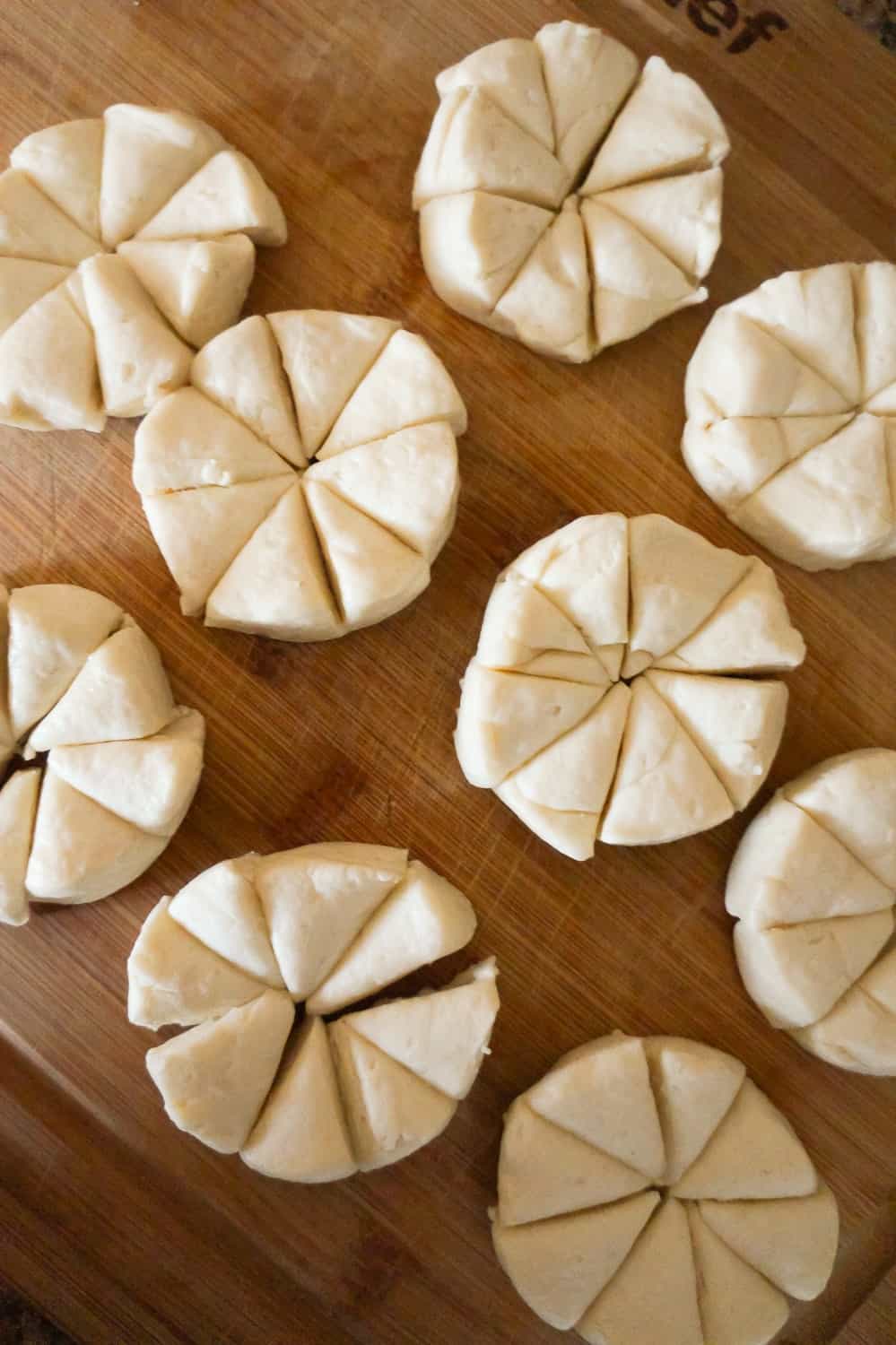 pillsbury biscuits cut into eight pieces each on a cutting board