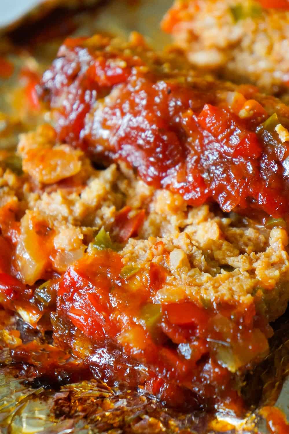 Sausage and Peppers Meatloaf is an easy meatloaf recipe using two pounds of mild Italian sausage meat and loaded with diced green peppers, red peppers and onions all in a sweet and spicy tomato sauce.