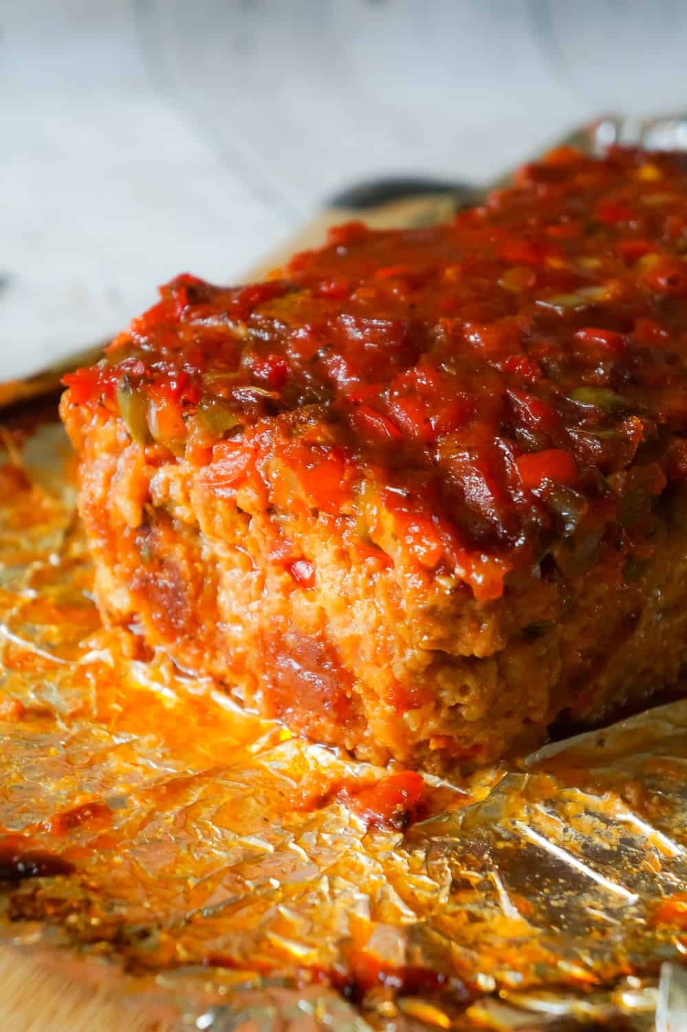 Sausage and Peppers Meatloaf is an easy meatloaf recipe using two pounds of mild Italian sausage meat and loaded with diced green peppers, red peppers and onions all in a sweet and spicy tomato sauce.