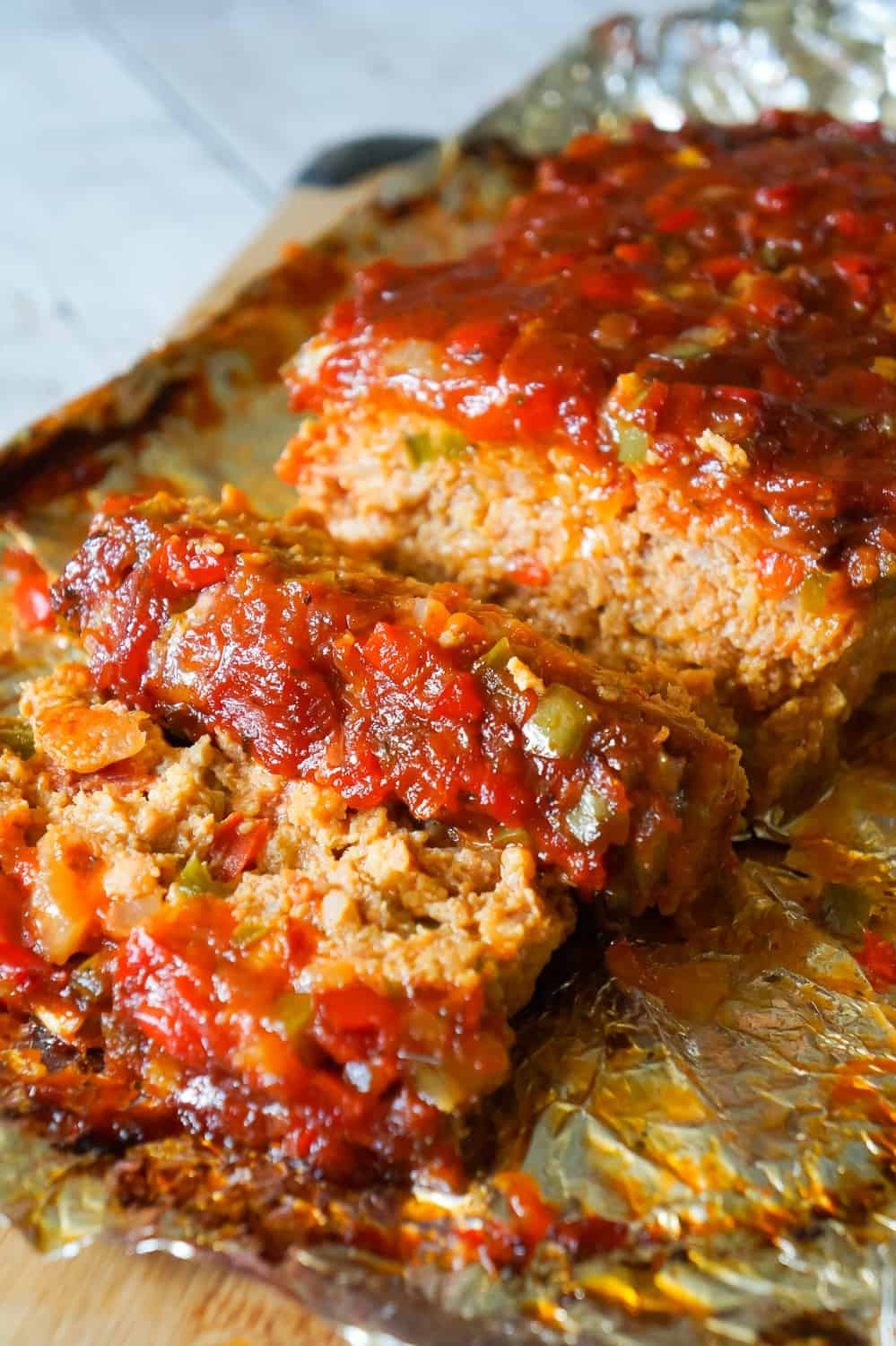 Sausage and Peppers Meatloaf is an easy meatloaf recipe using two pounds of mild Italian sausage meat and loaded with diced green peppers, red peppers and onions all in a sweet and spicy tomato sauce.