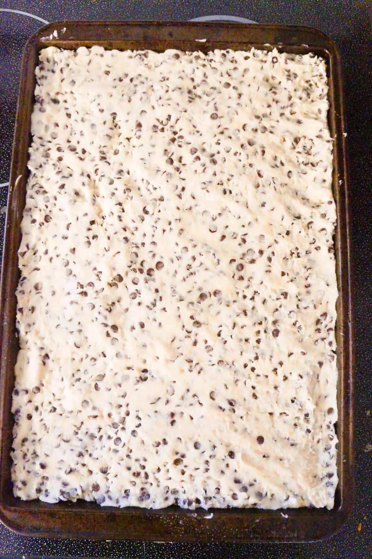 chocolate chip shortbread dough pressed out on a cookie sheet