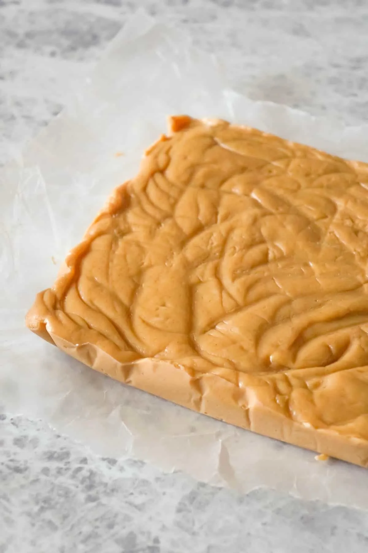 Easy Peanut Butter Fudge is an easy three ingredient microwave fudge recipe made with vanilla frosting, Reese's peanut butter baking chips and smooth peanut butter.
