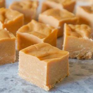 Easy Peanut Butter Fudge is an easy three ingredient microwave fudge recipe made with vanilla frosting, Reese's peanut butter baking chips and smooth peanut butter.