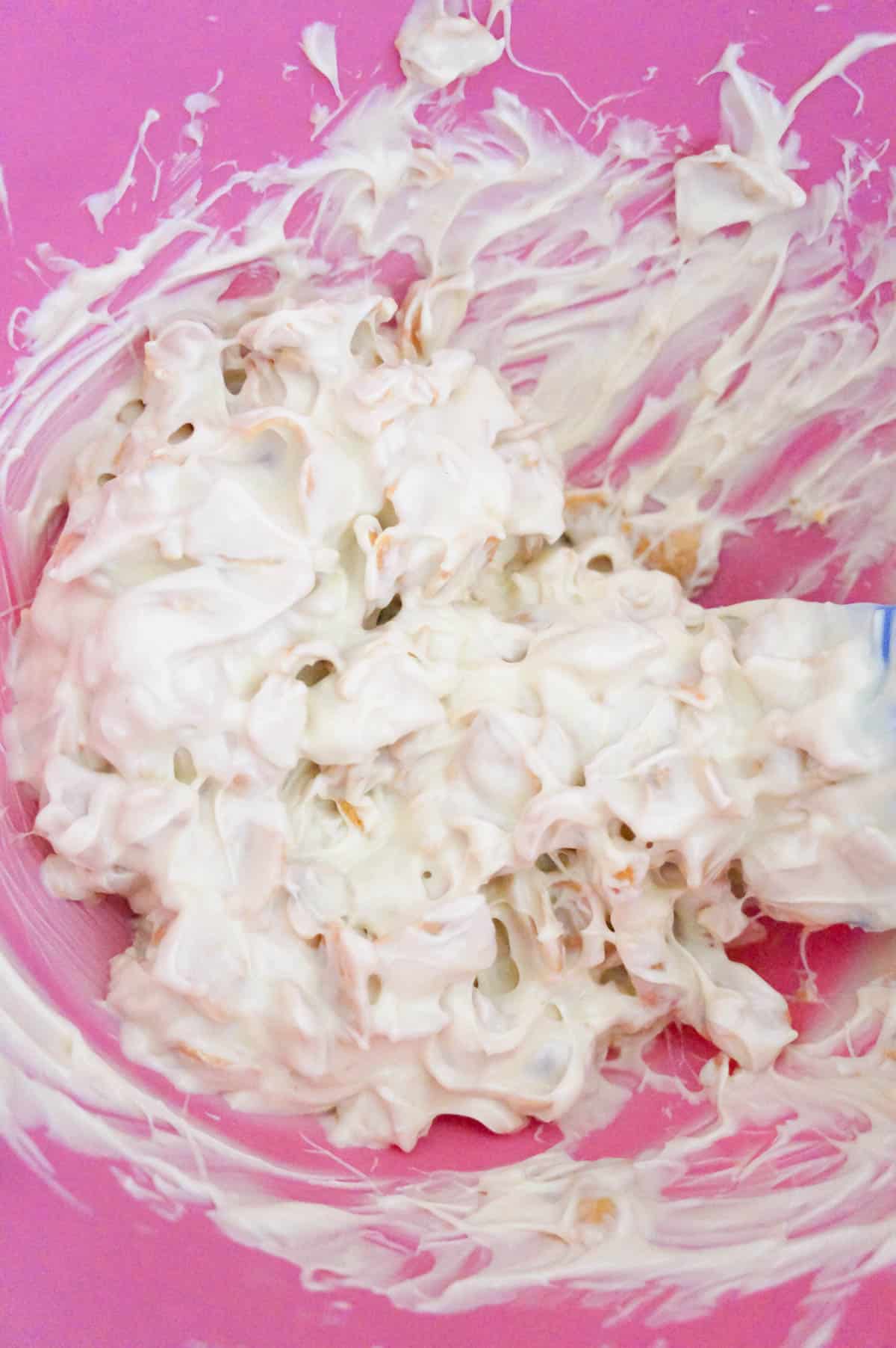 corn chips coated in white chocolate in a mixing bowl