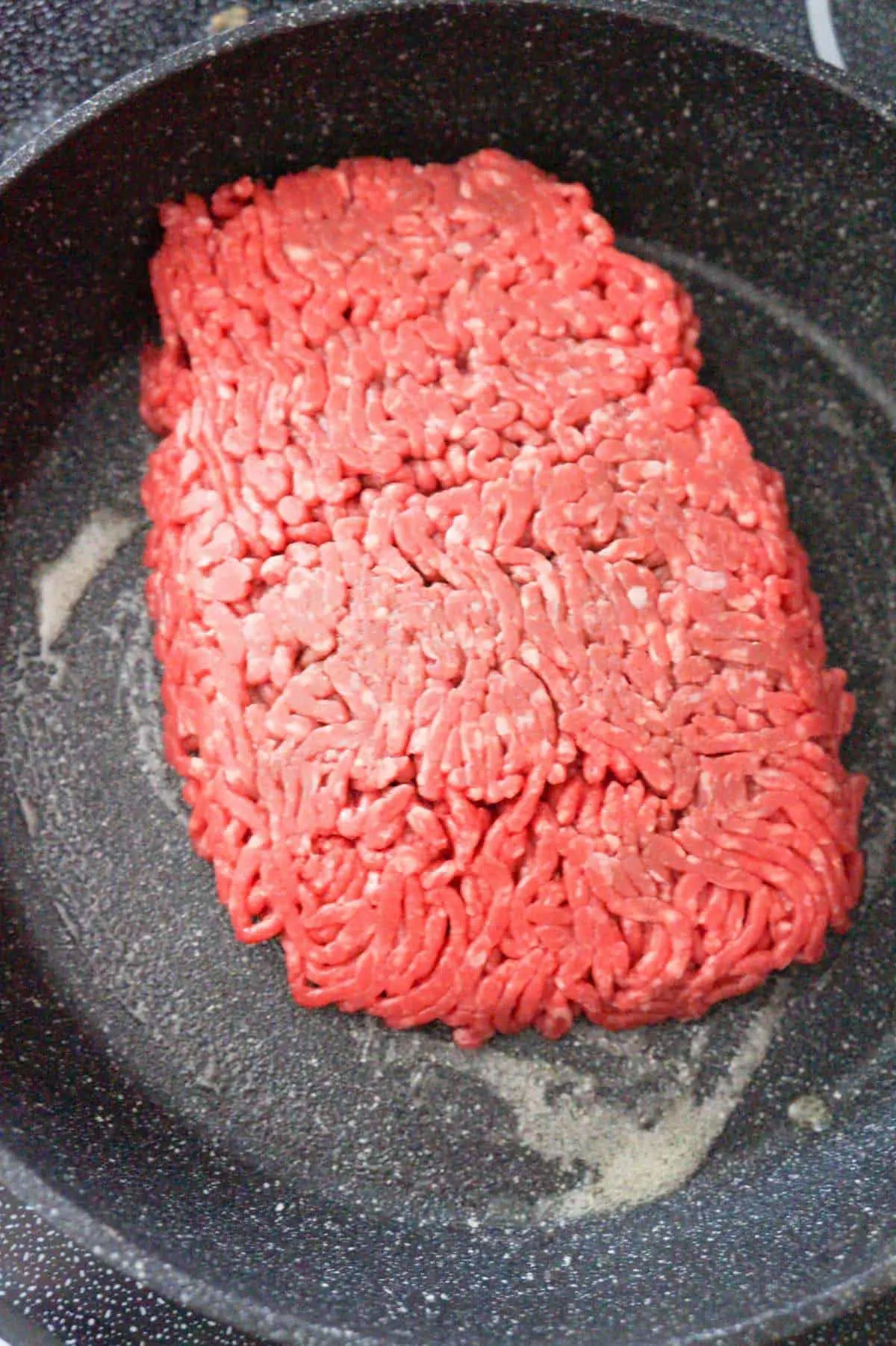 raw lean ground beef in a saute pan