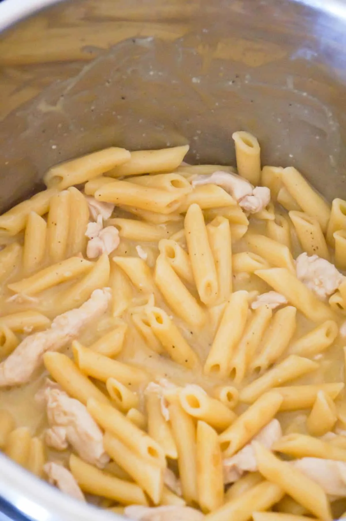cooked penne pasta and chicken breast strips in an Instant Pot