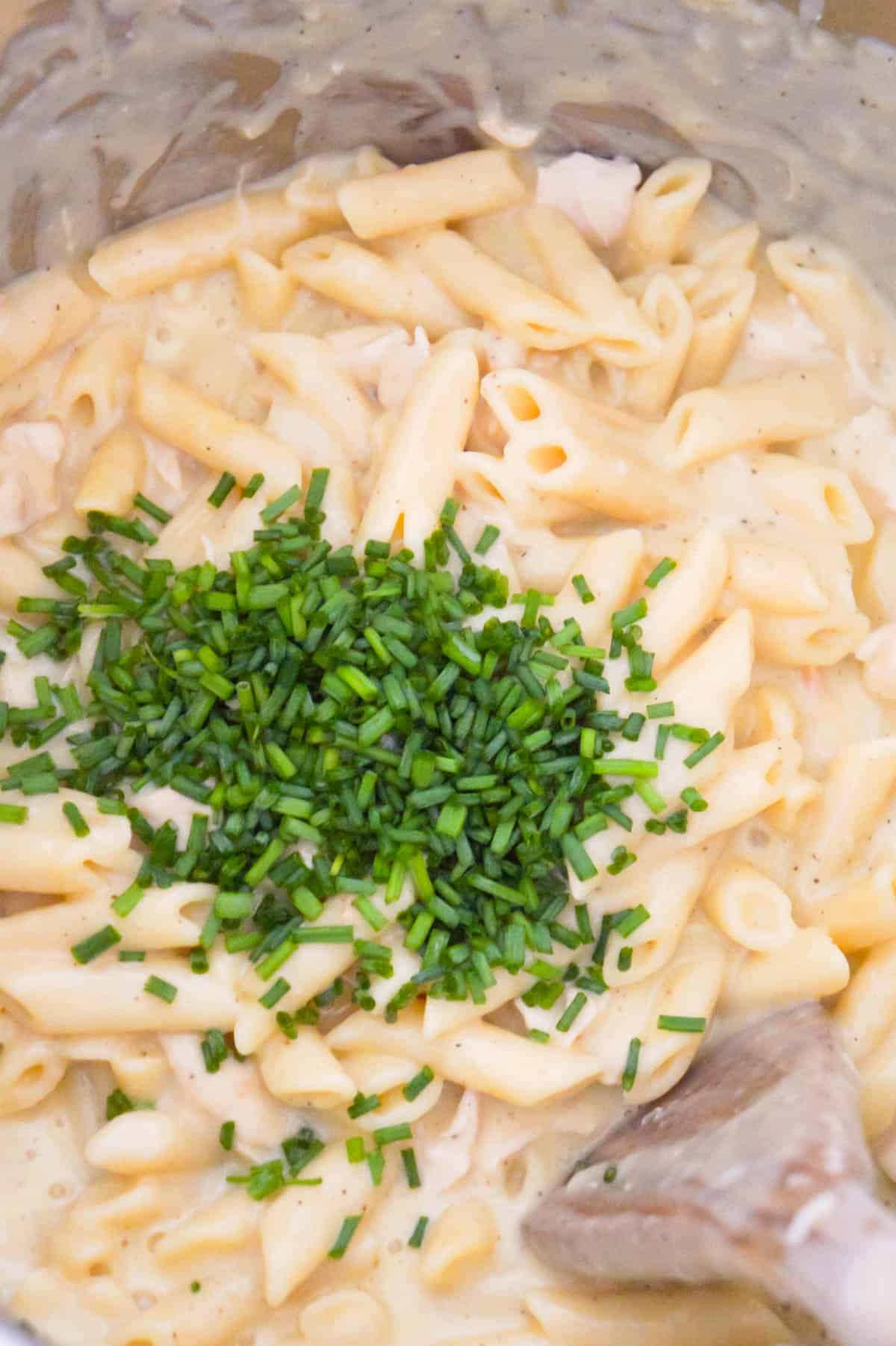 chopped chives on top of creamy penne pasta in an Instant Pot