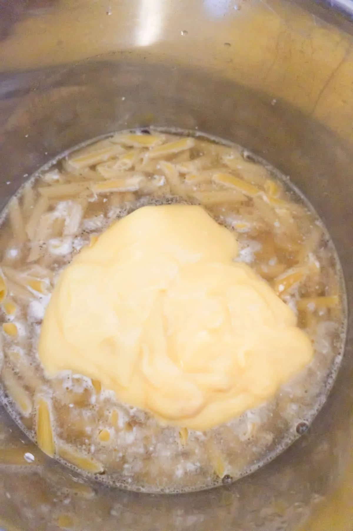 condensed cream of chicken soup on top of penne pasta in an Instant Pot