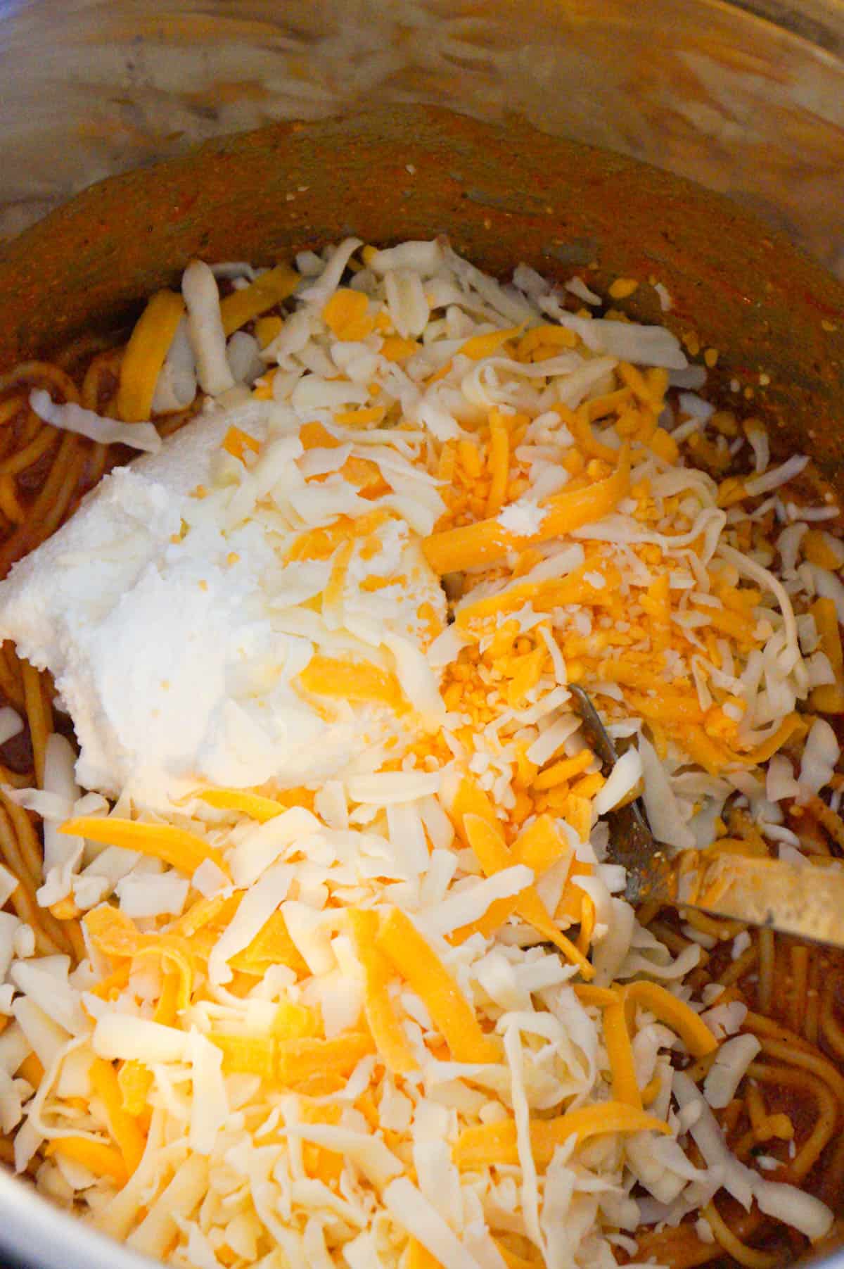 ricotta and shredded cheddar and mozzarella on top of cooked spaghetti in an Instant Pot
