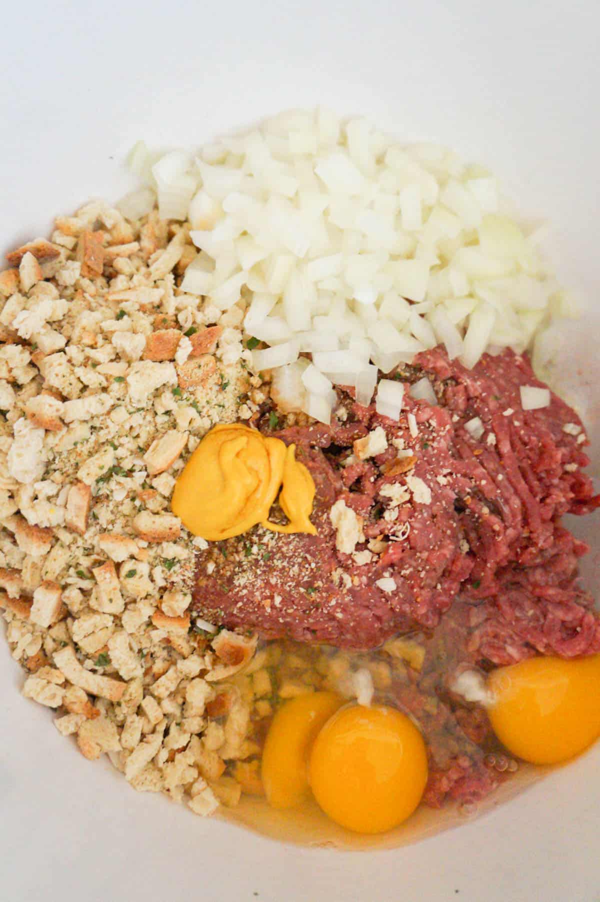 ground beef, stuffing mix, diced onions, eggs and mustard in a mixing bowl