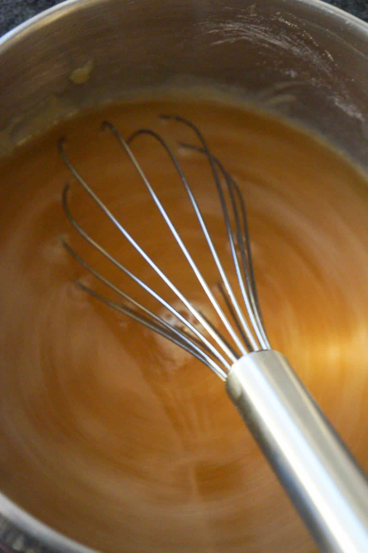 whisking gravy in a saucepan