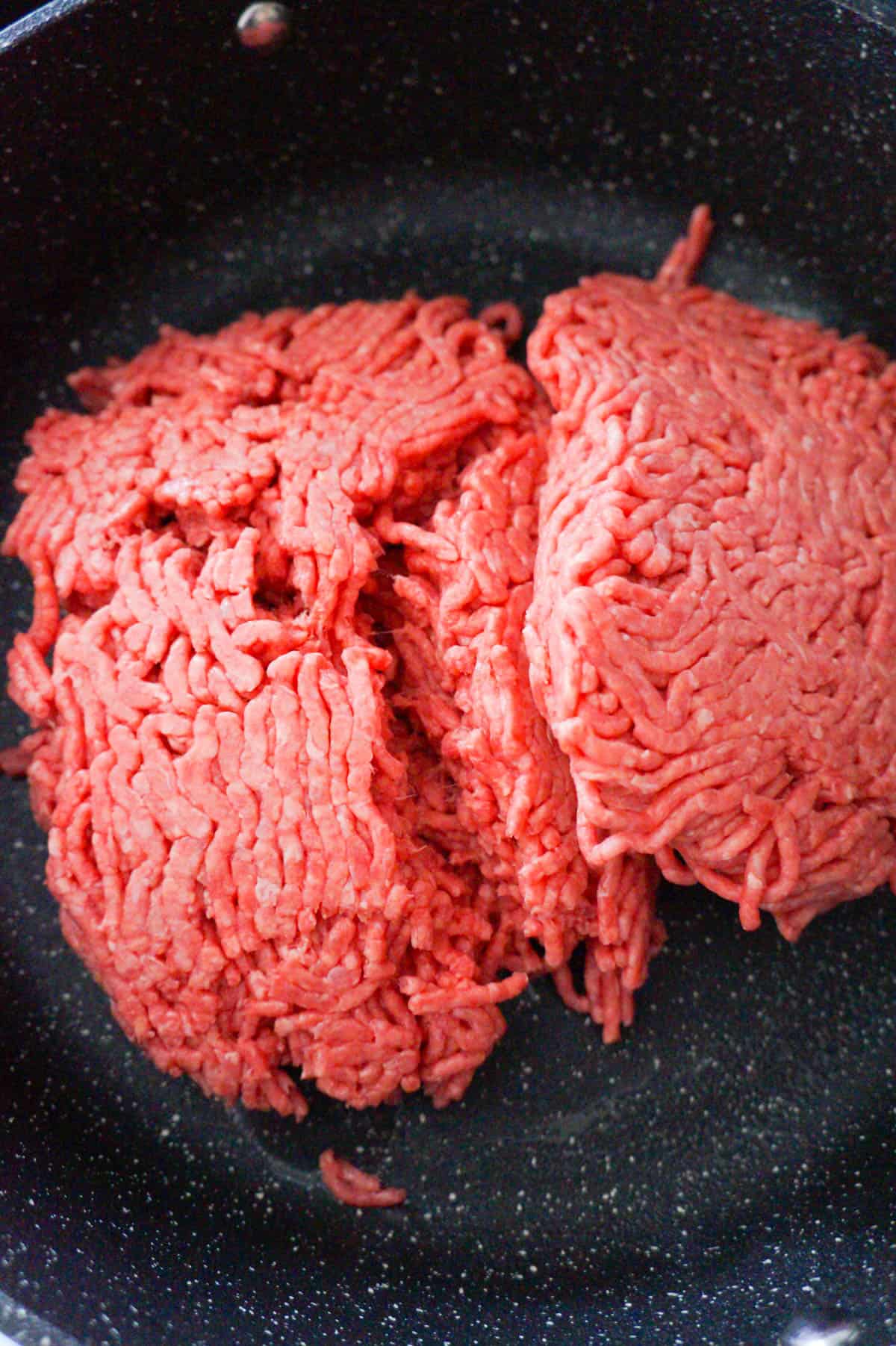 raw ground beef in a saute pan