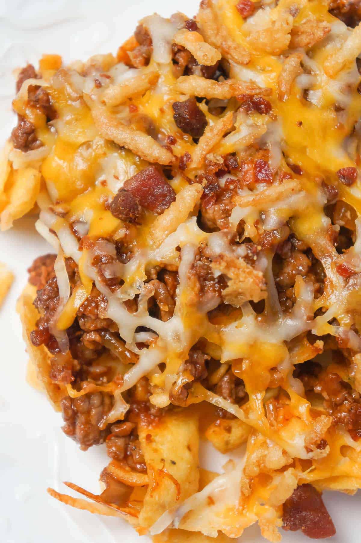 BBQ Bacon Cheeseburger Frito Pie is a delicous casserole with a base of Fritos corn chips, topped with ground beef and bacon crumble tossed in BBQ sauce, shredded cheese and French's fried onions.