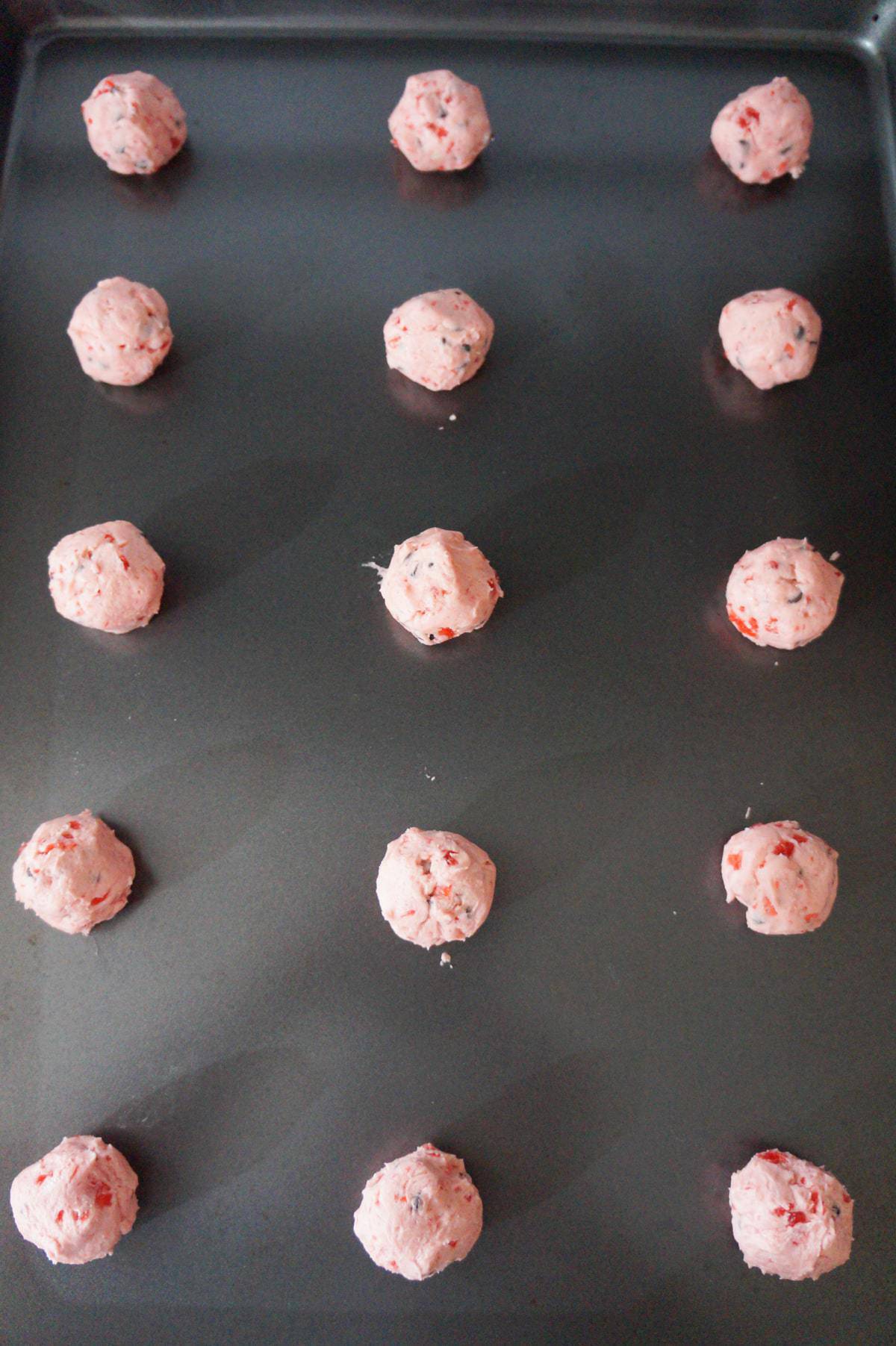 cherry chocolate chip shortbread cookie dough balls on a baking sheet