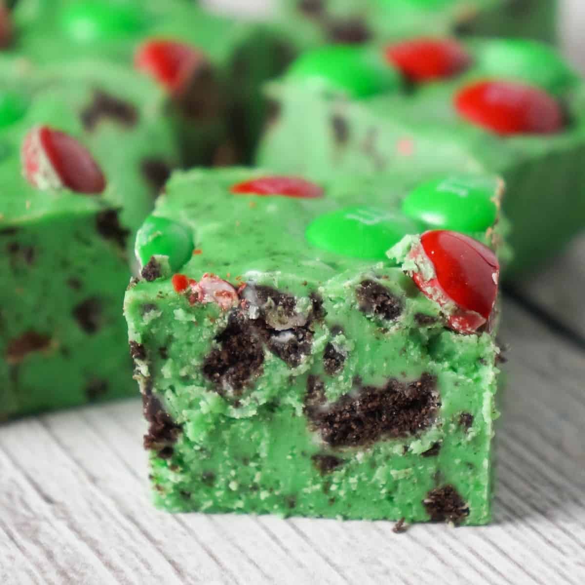 Cookies and Cream Christmas Fudge is an easy microwave fudge recipe made with vanilla frosting, white chocolate chips, green food colouring, crumbled Oreos and topped with red and green M&M's.